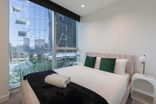 a bedroom with a bed and a large window at Supreme Sub-Penthouse - 3 Bedroom 2 Bathroom Melbourne CBD in Melbourne