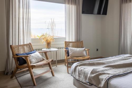 a bedroom with a bed and two chairs and a table at CASA SOL I PLATJA Calella Palafrugell con Parking in Calella de Palafrugell