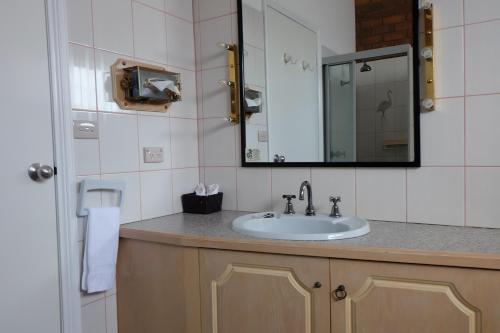 a bathroom with a sink and a mirror at Charles sturt motor inn in Cobram