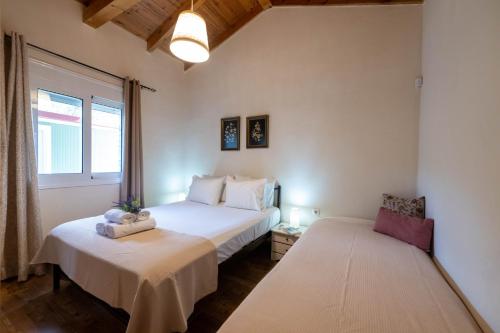 1 dormitorio con 2 camas y ventana en Olive Grove Getaway en Oikhalía