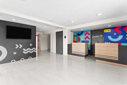 a lobby with a flat screen tv on a wall at Howard Johnson by Wyndham Orlando Lake Buena Vista South in Kissimmee