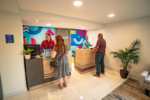 a group of people standing at a counter in a store at Howard Johnson by Wyndham Orlando Lake Buena Vista South in Kissimmee