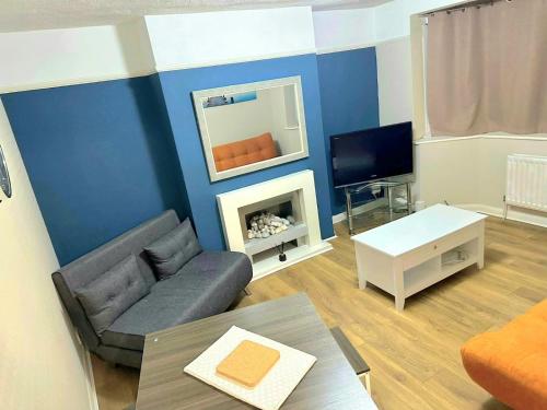 a living room with a couch and a tv at Letzi - Modern 2 Bedroom Apartment Near Heathrow in Hillingdon