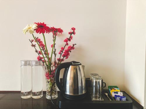 uma mesa com uma cafeteira e flores num vaso em Namdul Retreat em Phensāng