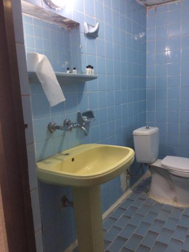 a bathroom with a yellow sink and a toilet at KAYAPALI OTEL in Bursa