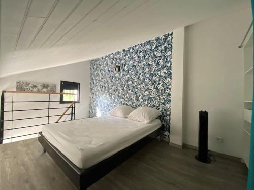 a bedroom with a bed with a blue and white wall at Appartement duplex - 2701 in Soulac-sur-Mer