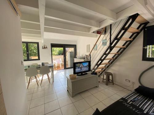 - un salon avec une télévision et un escalier dans l'établissement Appartement duplex - 2701, à Soulac-sur-Mer
