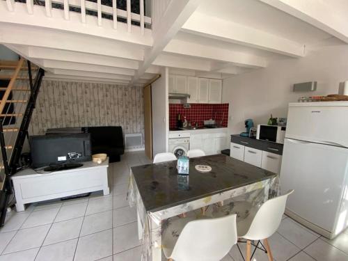 a kitchen with a white refrigerator and white chairs at Appartement duplex - 2701 in Soulac-sur-Mer
