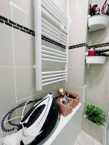 a bathroom with a hairdryer sitting on a shelf at Appartement proche stade de France et métro 12 in Saint-Denis
