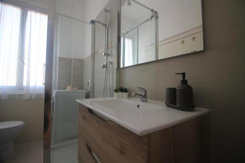 W łazience znajduje się umywalka, toaleta i lustro. w obiekcie PAPAPEO w mieście La Spezia