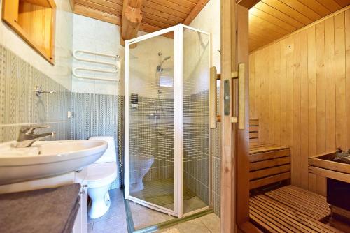 a bathroom with a shower and a toilet and a sink at Resort by Nava Lake in Aukštadvaris