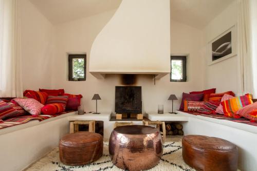 - un salon avec canapés et pouf en bois dans l'établissement Le Petit Mas, à Belvézet