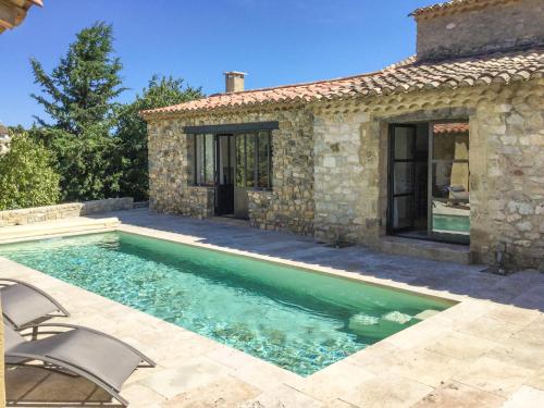 - une piscine en face d'une maison en pierre dans l'établissement Le Petit Mas, à Belvézet