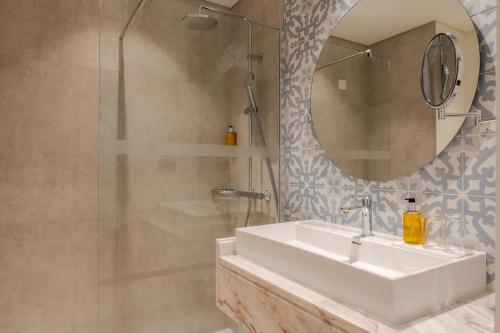 un bagno con lavandino e specchio di Sentido Galosol a Caniço