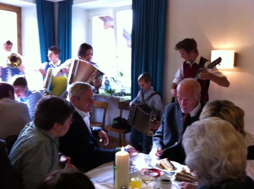 eine Gruppe von Menschen, die an einem Tisch mit Musik sitzen in der Unterkunft Ferienwohnungen Vierthaler in Filzmoos