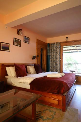 a bedroom with a large bed in a room at Kasar Himalaya Holiday Resort, Binsar Rd in Almora