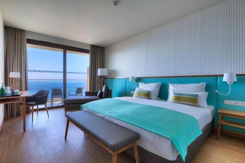 a hotel room with a large bed and a desk at Sentido Galomar - Adults Only in Caniço