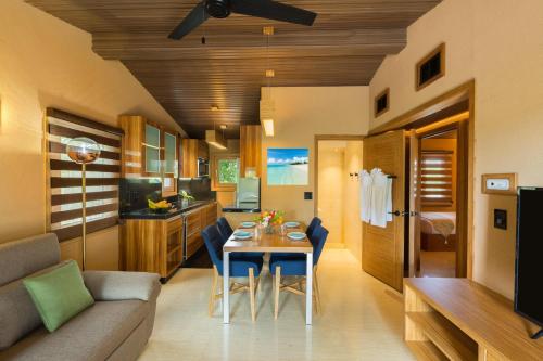 a living room and kitchen with a table and chairs at Kokomo Botanical Resort - Caribbean Family Cottages in Turtle Cove