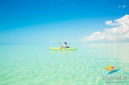 a person sitting on a kayak in the water at Kokomo Botanical Resort - Caribbean Family Cottages in Turtle Cove