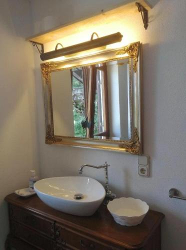 a bathroom with a white sink and a mirror at Appartment Hörnleblick in Bad Kohlgrub
