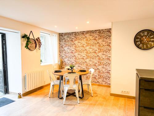 une salle à manger avec un mur en briques, une table et des chaises dans l'établissement *NEW*_ L'Industriel Chic au cœur de Ville _, à Guingamp