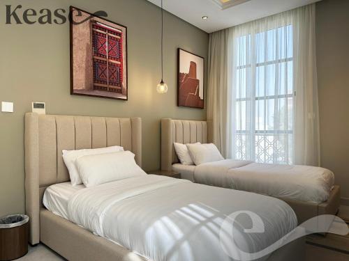 two beds in a room with a window at Kease Hittin N-12 Lusso Hejaz Balcony GZ83 in Riyadh