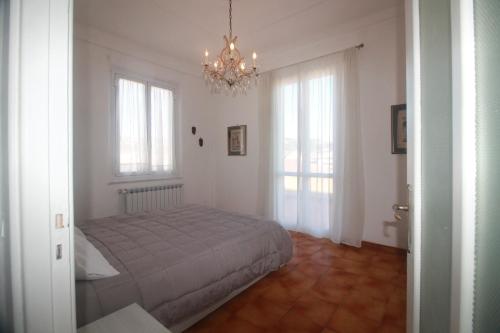 sypialnia z łóżkiem, oknami i żyrandolem w obiekcie PAPAPEO w mieście La Spezia