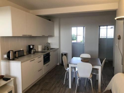 une cuisine avec une table et des chaises dans une pièce dans l'établissement Appartement avec vue sur la mer - A04110, à Soulac-sur-Mer