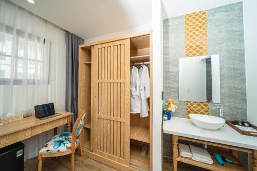 a bathroom with a sink and a desk at Cybele Sunset Hotel Phu Quoc in Phu Quoc