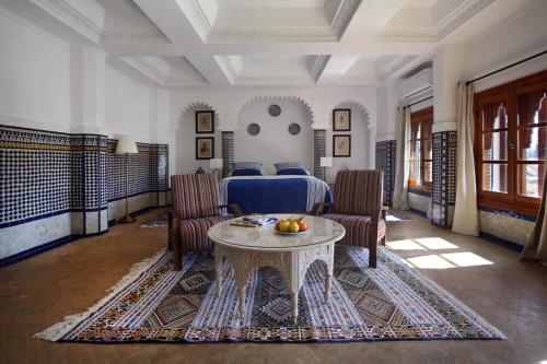 um quarto com uma cama, uma mesa e cadeiras em RIAD TANJA by chef Moha em Tânger