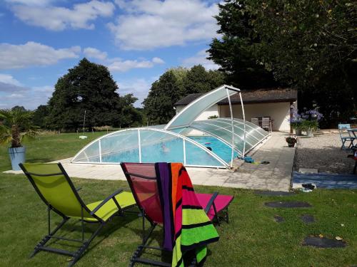 - un groupe de chaises assises en face d'une piscine dans l'établissement Maison familiale avec piscine, grand jardin clos et équipements de loisirs - FR-1-306-898, à Bonnœuvre