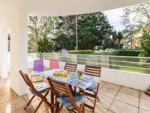 un patio avec une table et des chaises sur un balcon dans l'établissement Appartement Calme Proche Plage avec Terrasse Sud, Parking Sécurisé et Équipements Complets - FR-1-306-909, à Saint-Brévin-les-Pins