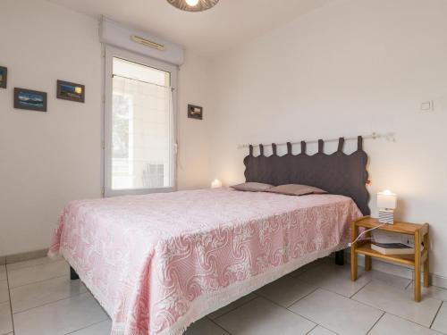 - une chambre avec un grand lit et un couvre-lit rose dans l'établissement Appartement Calme Proche Plage avec Terrasse Sud, Parking Sécurisé et Équipements Complets - FR-1-306-909, à Saint-Brévin-les-Pins