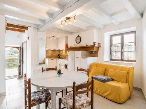une cuisine et une salle à manger avec une table et un canapé jaune dans l'établissement Charmante Maison Rénovée à 500m de la Mer avec Jardin, 2 Chambres, Parking Gratuit - FR-1-306-911, à Piriac-sur-Mer
