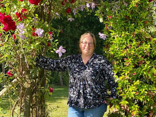a woman standing in front of a flower garden at Gîte rural confortable avec jardin clos, proche de Pornic, idéal pour familles, jeux et animaux bienvenus - FR-1-306-1042 in Frossay