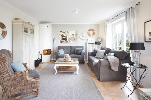 a living room with two couches and a table at Haus Amrumblick in Hedehusum