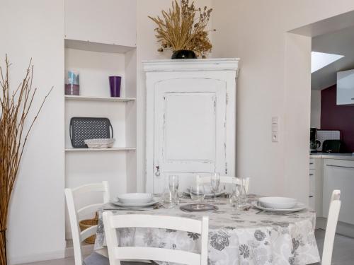 une salle à manger blanche avec une table et des chaises dans l'établissement Gîte tranquille à Pornic avec jardin privé, WiFi et garage vélos - FR-1-306-1058, à Pornic