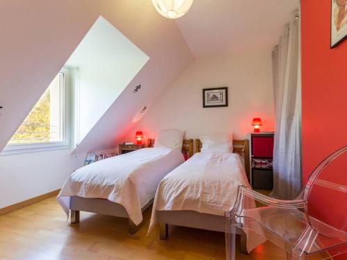 - 2 lits dans une chambre mansardée avec des murs rouges dans l'établissement Gîte Guérande, 5 pièces, 7 personnes - FR-1-306-1156, à Guérande