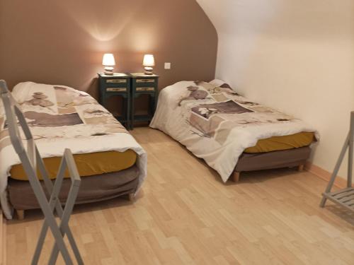 - deux lits dans une chambre avec deux tables et deux chaises dans l'établissement Gîte cosy avec jardin clos à Saint-Lyphard, proche Guérande, au cœur du parc de Brière - FR-1-306-1093, à Saint-Lyphard
