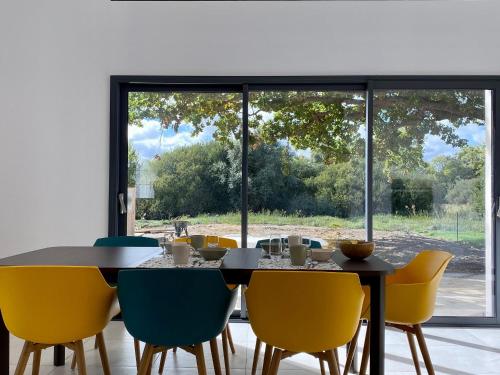 une salle à manger avec une table et des chaises jaunes dans l'établissement Maison moderne 3 chambres avec jardin, WIFI et équipement bébé dans la Brière - FR-1-306-1224, à Saint-Joachim