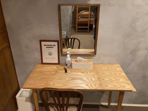 a table with a mirror and a table with a box on it at Nawate Guesthouse in Matsumoto