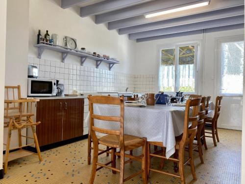 une cuisine avec une table et des chaises dans une cuisine dans l'établissement Maison de vacances spacieuse près de la forêt, avec jardin, cheminée, wifi, et équipements de loisirs. - FR-1-306-1223, à Le Gâvre