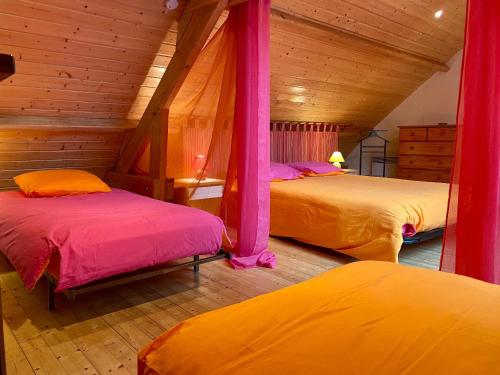 1 Schlafzimmer mit 2 Betten mit rosa und gelber Bettwäsche in der Unterkunft Gîte Mésanger, 2 pièces, 6 personnes - FR-1-306-1219 in Mésanger