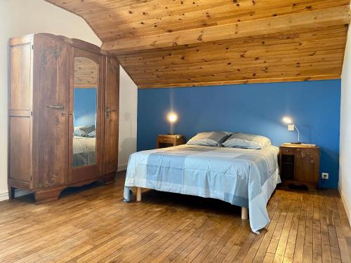 sypialnia z łóżkiem i drewnianym sufitem w obiekcie Maison de vacances spacieuse près de la forêt, avec jardin, cheminée, wifi, et équipements de loisirs. - FR-1-306-1223 w mieście Le Gâvre