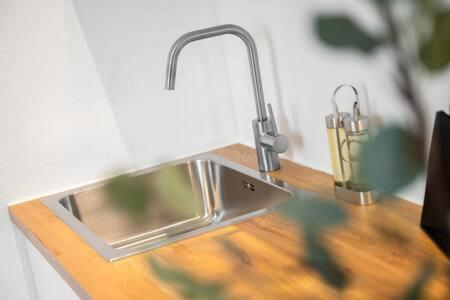 a kitchen sink with a faucet on a wooden counter at 2bedroom in historic villa near Nymphenburg Palace in Munich