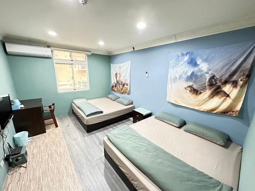 een slaapkamer met blauwe muren en een bed en een bank bij Myhome Homestay in Nangan