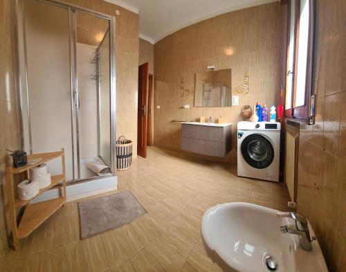 a bathroom with a sink and a washing machine at Apartament Cedro del Libano in Marano