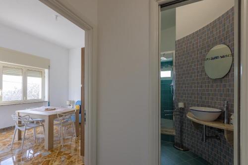 uma casa de banho com uma mesa e uma cabina de duche em vidro em Casa Vacanze Fernanda em Torre Vado