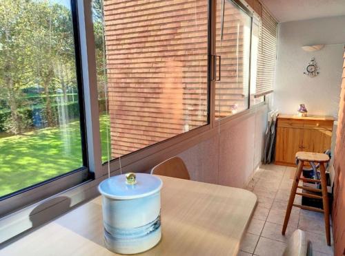 une pièce avec une table et une grande fenêtre dans l'établissement Appt 4 personnes en résidence,Wifi, Parking., à Cabourg