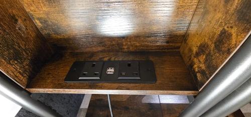 a remote control sitting on top of a wooden table at Modern 2 bedrooms apartment in Town centre in Ipswich